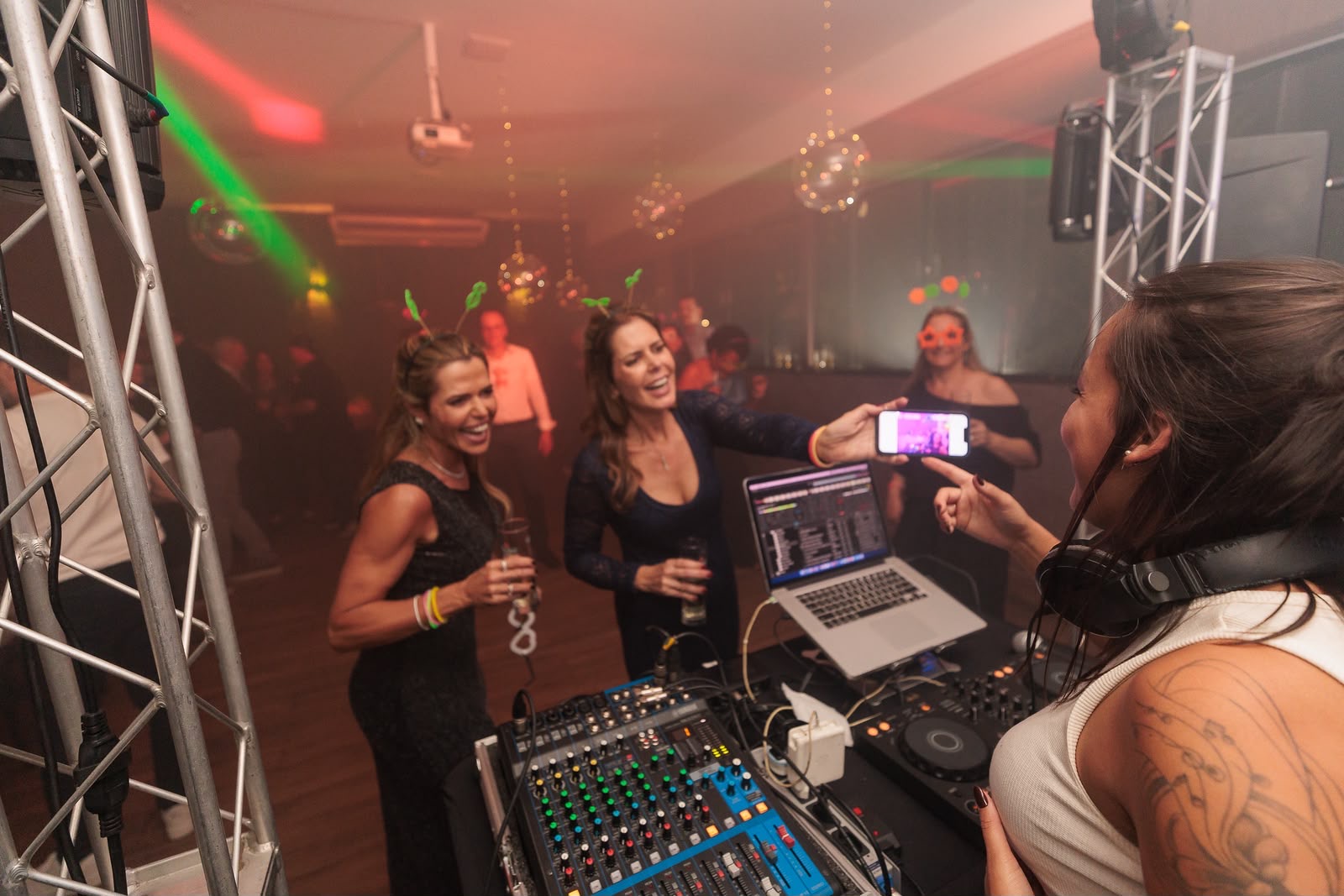 DJ Thaa interagindo com convidadas durante um evento