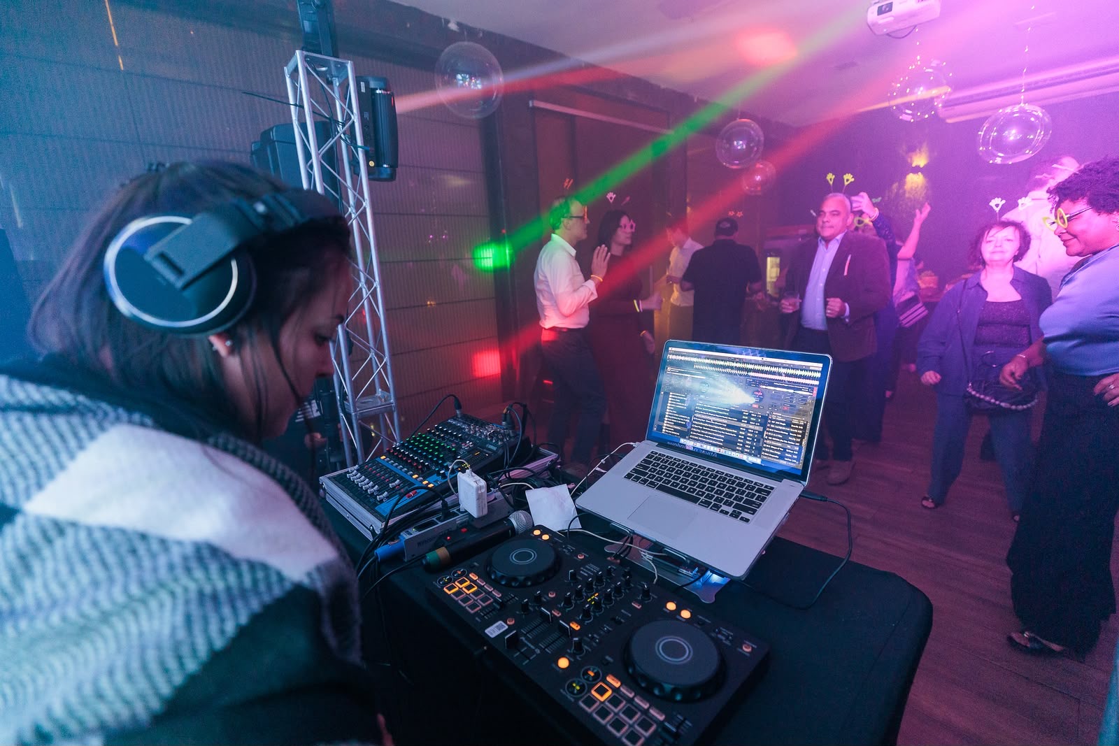 DJ Thaa tocando com a pista iluminada ao fundo